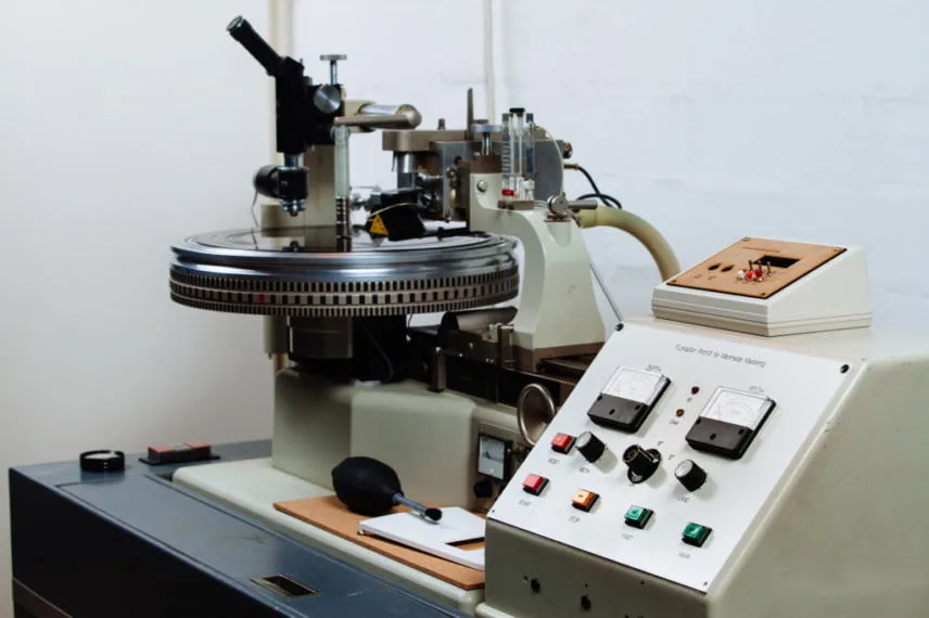 Neumann Vinyl Cutting Lathe for Vinyl Mastering "Close-up of a Neumann vinyl cutting lathe, featuring the turntable and control panel used in the process of mastering vinyl records.