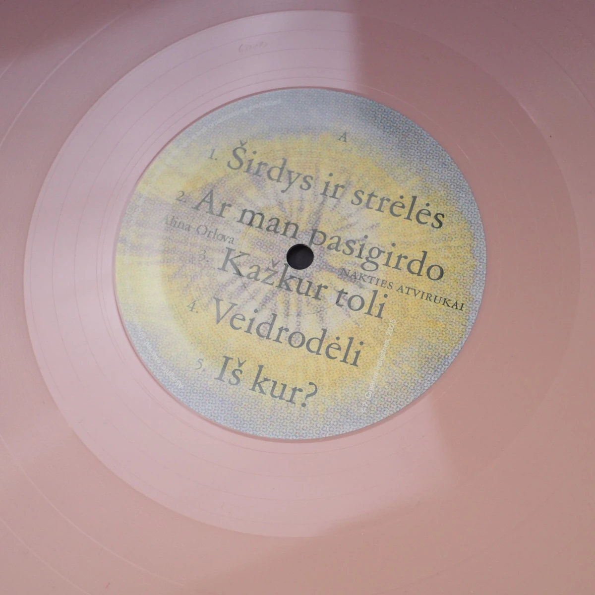 A-side of the pink vinyl record with pastel yellow and blue center label.
