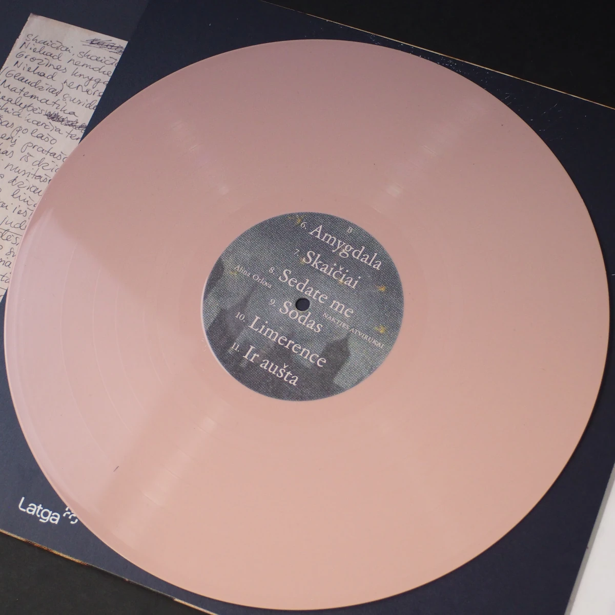 B-side of the pink vinyl record with dark center label and tracklist.