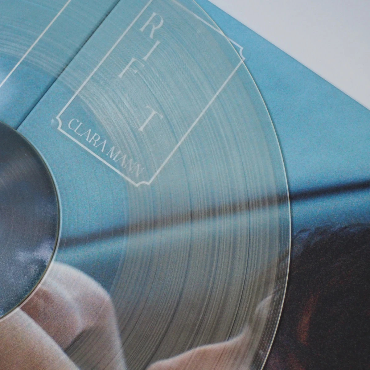 Clear vinyl record over standard Clara Mann – Rift cover.