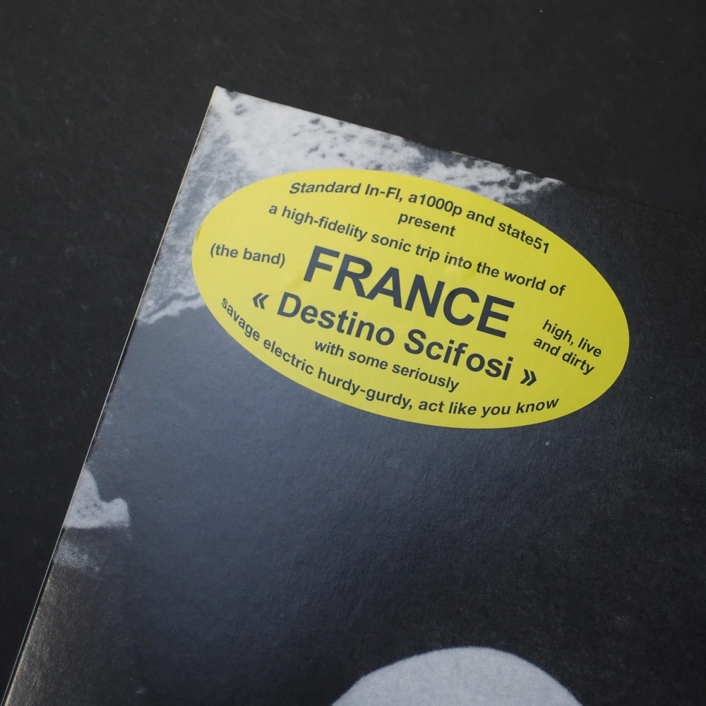 Yellow oval hype sticker on album cover for France – Destino Scifosi.