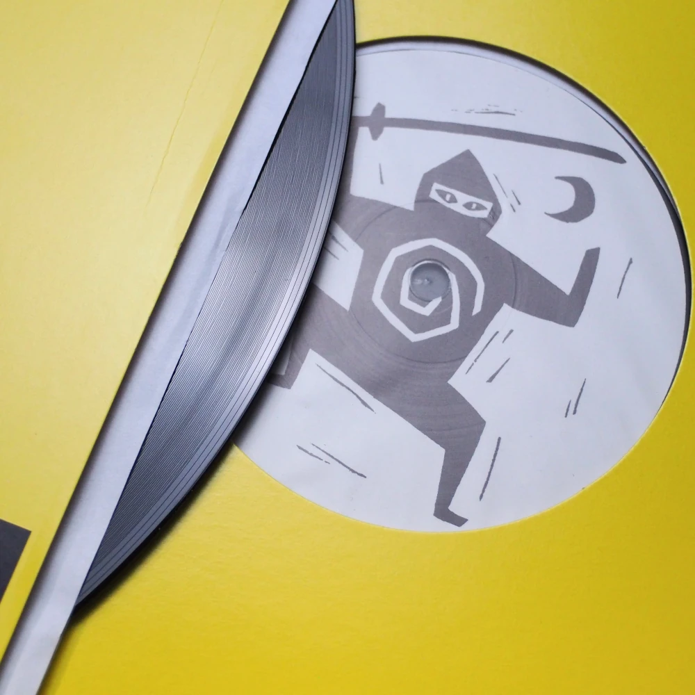 Ninja Tune logo printed on record center label, partially revealed from sleeve.