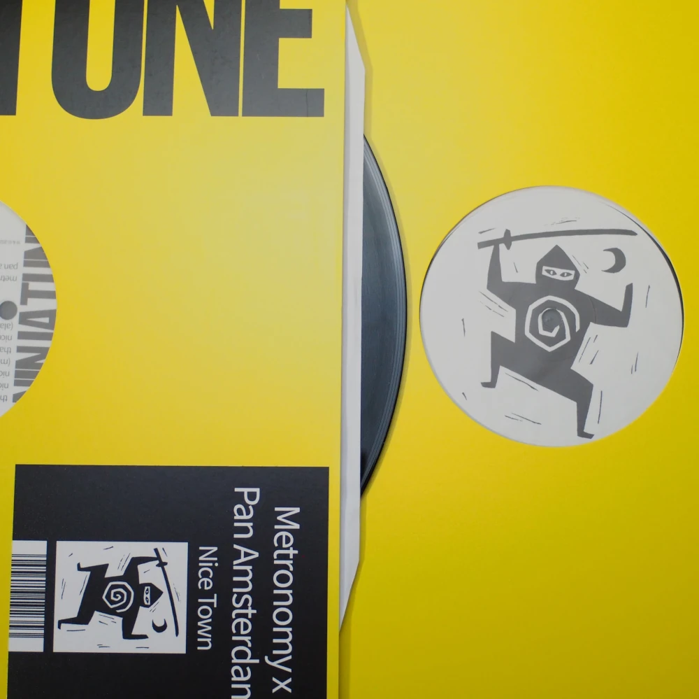 Close-up showing label and barcode sticker on Ninja Tune yellow jacket.
