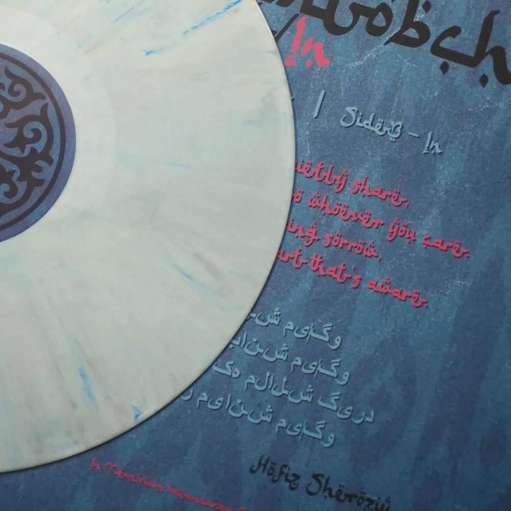 Full view of Qorakitobchi’s Out/In A-side marbled vinyl laid over the album artwork and sleeve design