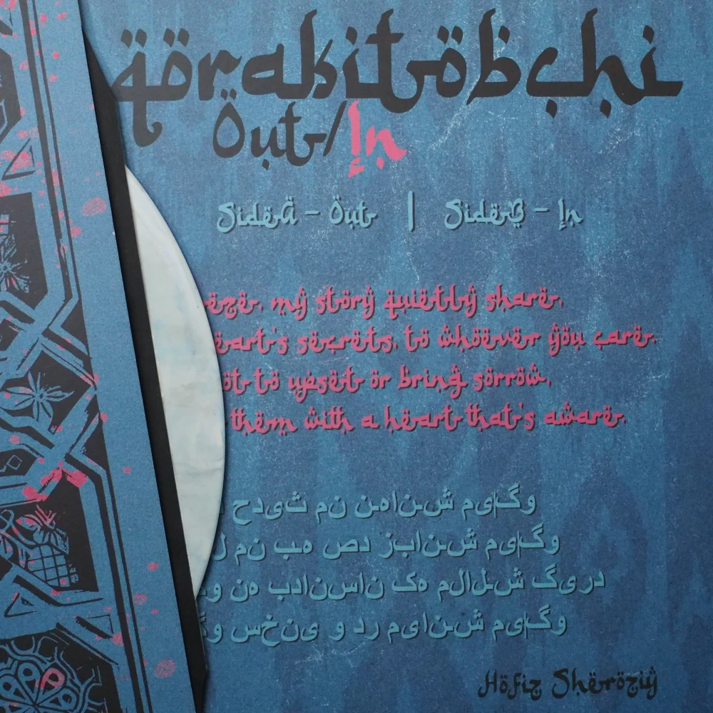 Side A of Qorakitobchi’s Out/In on marbled white vinyl with blue streaks and custom ornamental label design
