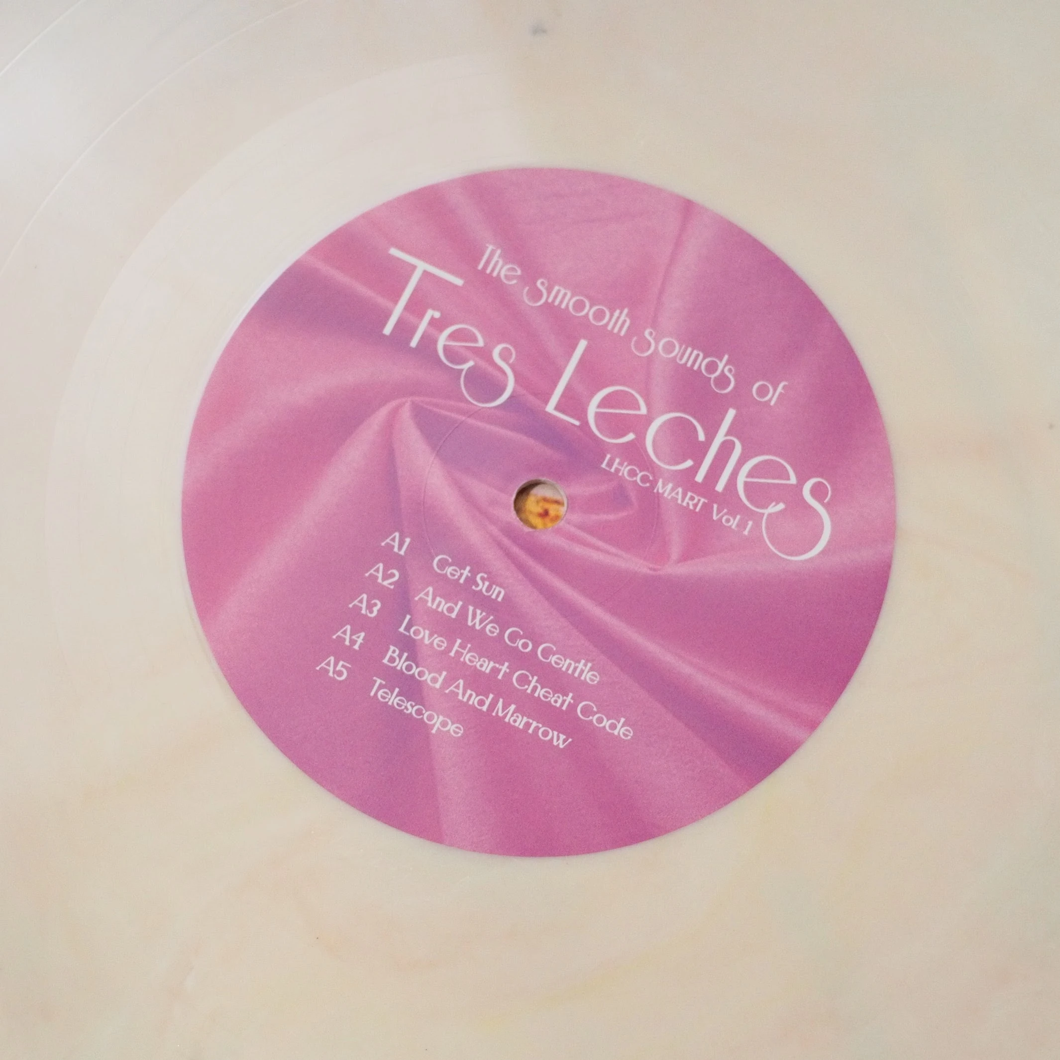 Center label of Tres Leches record with magenta satin texture.