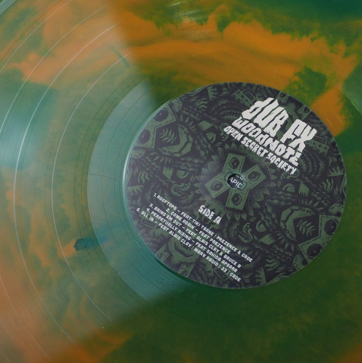 Close-up of color-in-color green and orange vinyl record with Side A label.