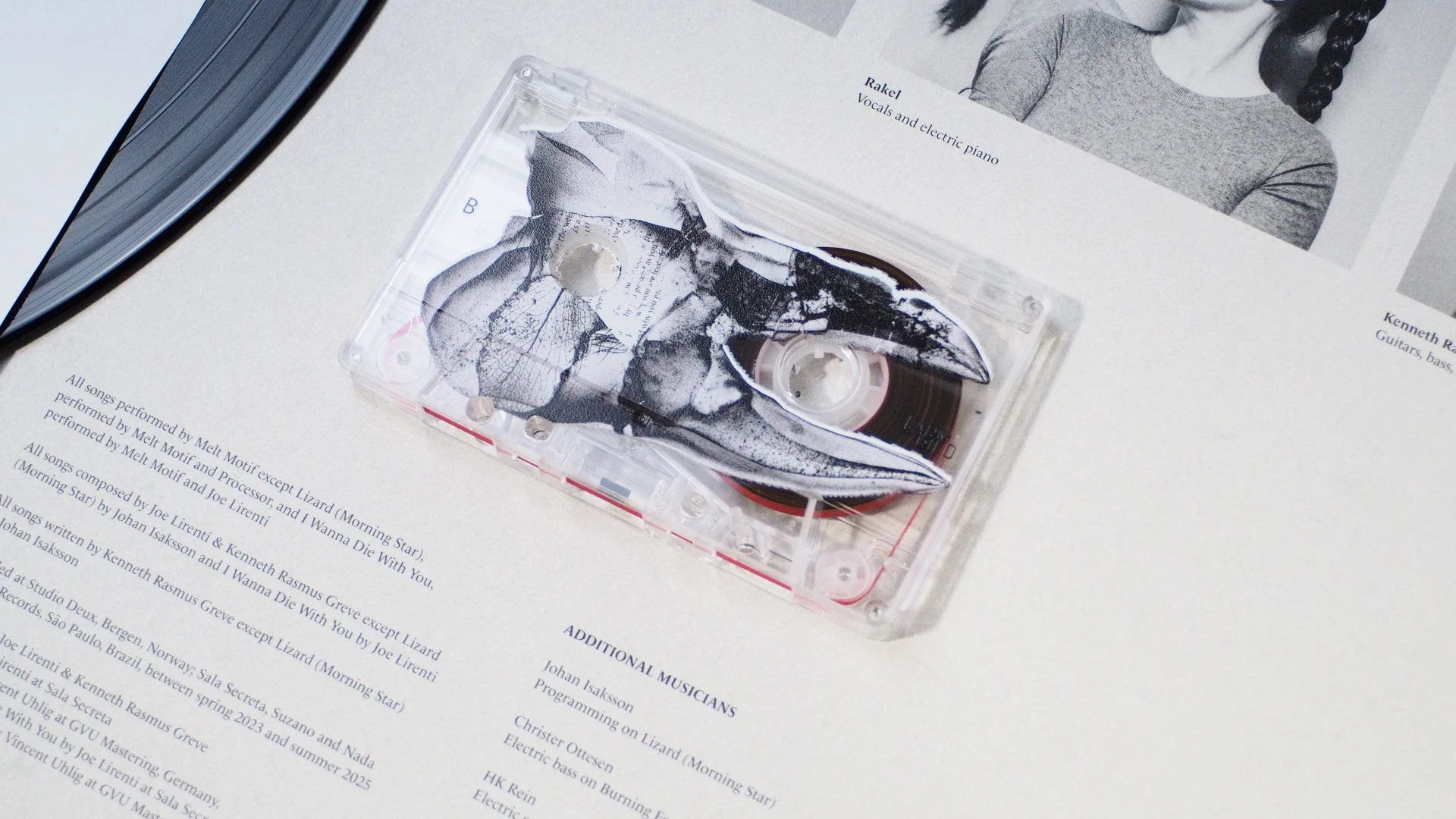 Close-up of transparent cassette with black claw artwork overlayed on tape shell.