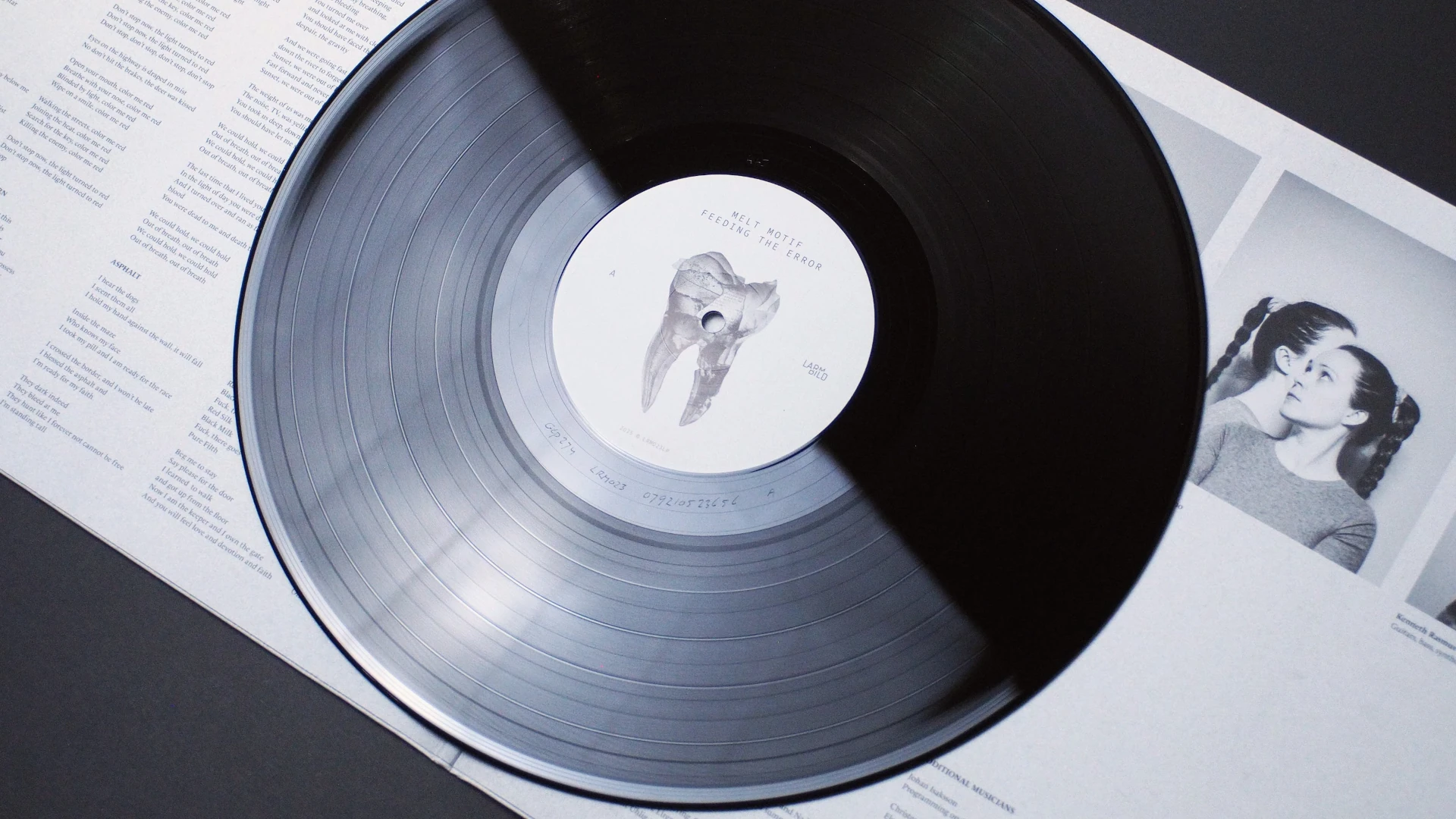 Vinyl record lying on top of open gatefold sleeve with artist portraits underneath.