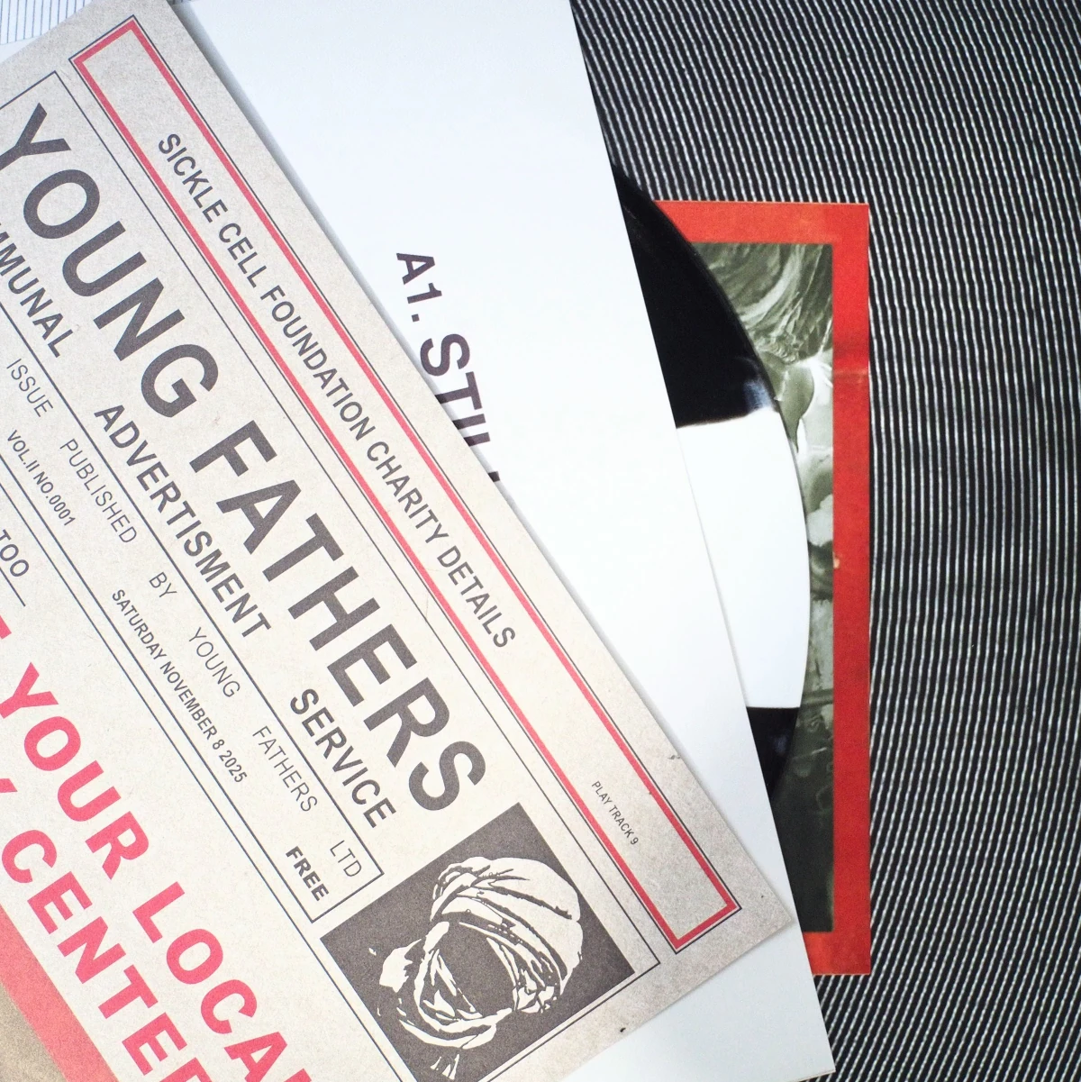 Folded poster lying over vinyl record of Young Fathers release.
